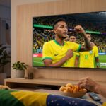Smart TV de tela grande exibindo uma partida de futebol