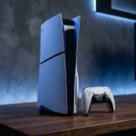 Console PlayStation 5 Slim Edição Digital em pé ao lado do controle sem fio DualSense em estúdio