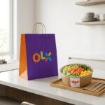 Sacola de entrega roxa oficial da OLX ao lado de refeição delivery com embalagem oficial do iFood