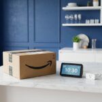 Caixa de entrega da Amazon ao lado de dispositivo inteligente Echo em balcão moderno